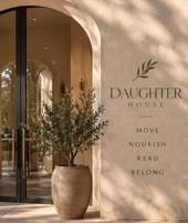 Sunlit arched entrance with a DaughterHouse welcome wall