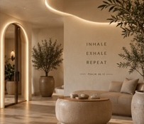 Quiet lounge with a low table and a wall reading inhale, exhale, repeat