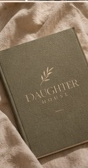 Sage green DaughterHouse notebook on textured natural fabric
